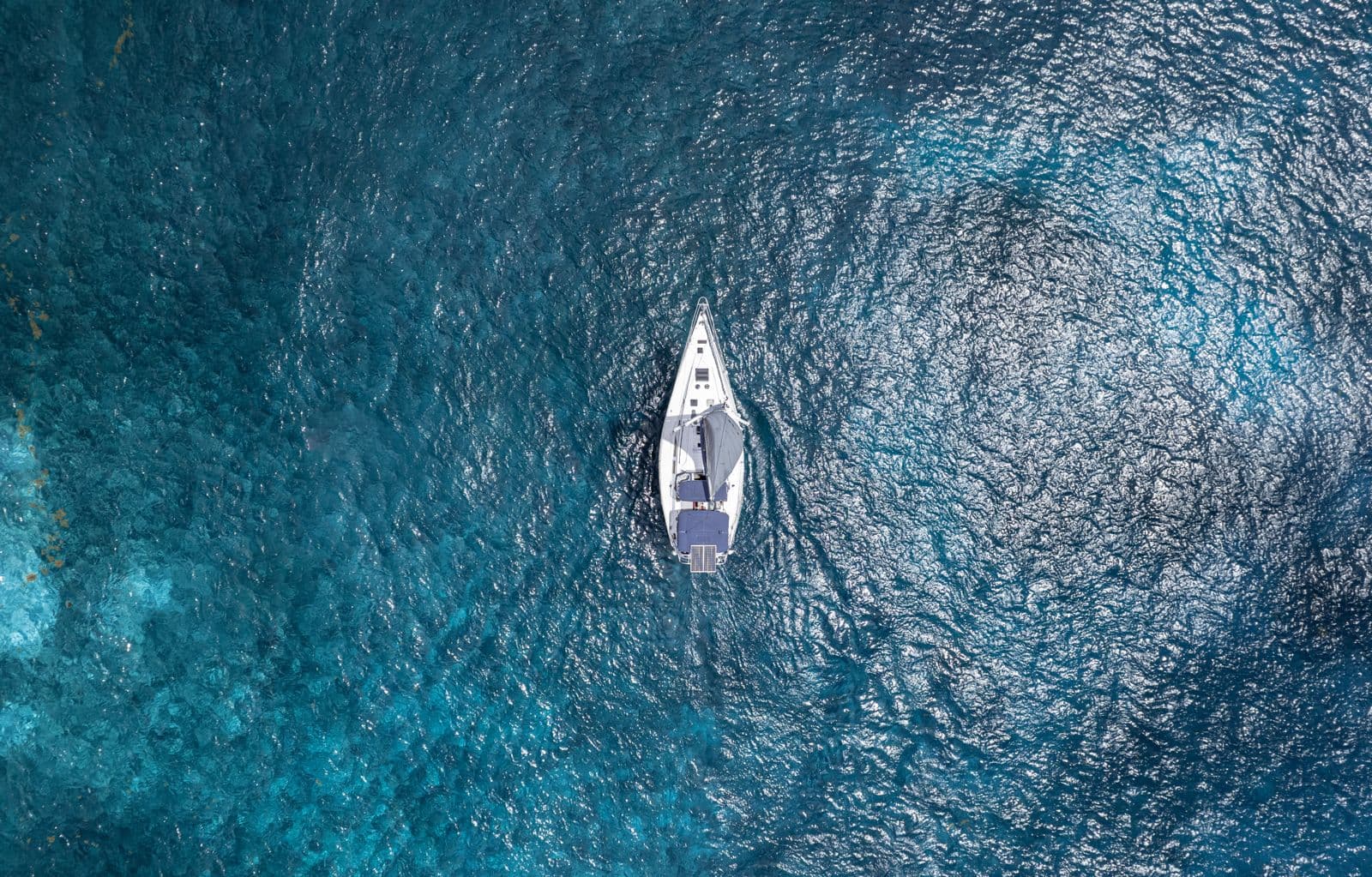Top-down aerial of SISU on clear turquoise Caribbean water